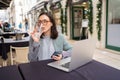 Freelancer using smartphone and laptop sitting outdoor cafe drink water Royalty Free Stock Photo