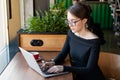 Freelancer woman working on laptop in cafe. Distance job and remote work concept Royalty Free Stock Photo