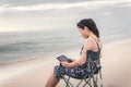 Freelancer Woman is Working on Tablet While Travel Vacation Trip at The Beach, Smart Woman is Using Tablet for Communication and Royalty Free Stock Photo