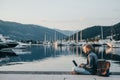 Freelancer working on laptop on the shore near the yacht boat at Royalty Free Stock Photo