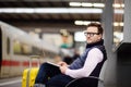 Freelancer working with a laptop in a train station while is waiting for transport Royalty Free Stock Photo