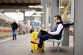 Freelancer working with a laptop in a train station while is waiting for transport Royalty Free Stock Photo