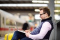 Freelancer working with a laptop in a train station while is waiting for transport Royalty Free Stock Photo