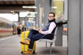 Freelancer working with a laptop in a train station while is waiting for transport Royalty Free Stock Photo