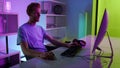 Freelancer working neon lights room. Serious man using pc surfing internet home Royalty Free Stock Photo