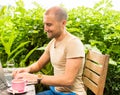 Freelancer working in park. Man sitting at rough country wooden