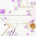 Freelancer workspace with clipboard, notebook, pink flowers and accessories on rustic wooden table. Flat lay, top view Royalty Free Stock Photo