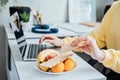 Freelancer young woman eating healthy food when working from home. Woman eating Healthy Grain Snacks and fruits while Royalty Free Stock Photo