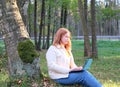 Freelancer young woman plus size working with laptop, sunlight effect on face. Outdoor, mobile office Royalty Free Stock Photo