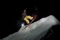 Snowboarder with dreadlocks dressed is jumping in in the mountains at night Royalty Free Stock Photo