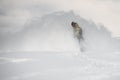 Freerider slides on a snowboard through snow cloud