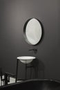 Freestanding black bathtub, stylish minimalist black and white loft style bathroom. Bath, washstand, mirror on the wall