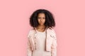 Freestyle. African girl in denim jacket standing isolated on pink looking camera pensive Royalty Free Stock Photo