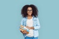 Freestyle. African girl student wearing glasses standing isolated on gray with books smiling playful Royalty Free Stock Photo