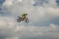 Freestyle Motocross rider carries out a trick with the motorcycle on background of the blue cloud sky. Flying in the sky on a moto Royalty Free Stock Photo