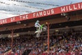 Freestyle motocross team member launches off ramp into the air during performance