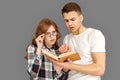 Freestyle. Young couple students standing  on grey reading book looking at page concerned close-up Royalty Free Stock Photo