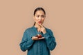 Freestyle. Young woman in denim dress standing isolated on bage holding fruit tart biting lip concerned thinking of Royalty Free Stock Photo