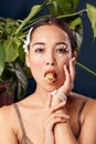 Freestyle. Young woman eyes decorated with perls wearing bracelet standing isolated on dark blue with plants holding Royalty Free Stock Photo