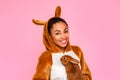 Freestyle. Young woman in kigurumi standing isolated on pink with rabbit smiling confident close-up Royalty Free Stock Photo