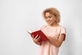Freestyle. Young woman standing isolated on grey reading book smiling joyful Royalty Free Stock Photo
