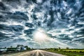 Freeway through country landscape with dramatic skyes and sun ra Royalty Free Stock Photo