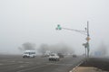 Freeway and intersection with traffic lights in dense fog