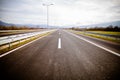 Freeway on a sunny day trough scenic green meadows.Motorway traveling long distance.Asphalt highways road. Royalty Free Stock Photo