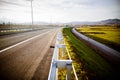 Freeway on a sunny day trough scenic green meadows.Motorway traveling long distance.Asphalt highways road in rural scene use land Royalty Free Stock Photo