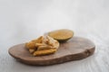 Freeze-dried mango with fresh one on olive wood board with copy space