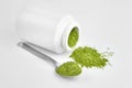 Freeze dried young organic wheatgrass powder in teaspoon and jar on white Royalty Free Stock Photo