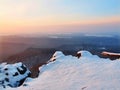 Freeze fallen trunk covered with fresh powder snow, stony rock peak increased from foggy valley. Winter misty sunrise in rocks. Royalty Free Stock Photo