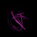 Freeze light photo, abstract streaks pink color on black background, made with light painting or light drawing