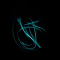 Freeze light photo, made with light painting or light drawing, abstract streaks turquoise color on black background