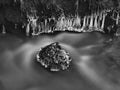 Freeze mossy sandstone boulder in dark cold water Royalty Free Stock Photo