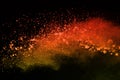 Freeze motion of colorful powder exploding on black background.