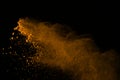 Freeze motion of gold powder explosions isolated on black background. colored dust explosive on dark background. Colorful cloud s