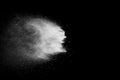 Freeze motion of white dust particles on black background. White powder explosion