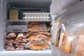 freezer of modern frigerator full with frozen food products in quarantine or work from home period