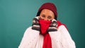 Freezing cold woman bundles up against the cold, huddles in warm scarf, studio Royalty Free Stock Photo