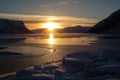 freezing fiord at sunrise, with the sun emerging over the horizon