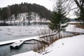 Freezing lake in winter with holes, with pier, wooden boats Royalty Free Stock Photo