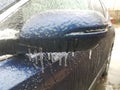 freezing rain ice on car side mirror in winter Royalty Free Stock Photo