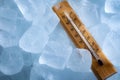 Freezing temperatures and cold weather concept with a vintage thermometer surrounded by blue ice showing sub zero temperature with Royalty Free Stock Photo