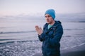 Freezing young man on the beach. Man feels freeze rubs and warms her hands. Royalty Free Stock Photo