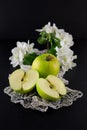 Freh ripe green apple decorated with beautiful apple blossom on dark table