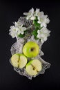 Freh ripe green apple decorated with beautiful apple blossom on dark table