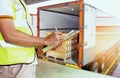 Freight industry warehouse shipments transport. Worker courier holding clipboard inspecting checklist load cargo into a truck.