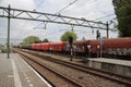 Freight locomotive with cargo wagons along platform of train station Den Haag Laan van NOI