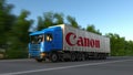 Freight semi truck with Canon Inc. logo driving along forest road. Editorial 3D rendering